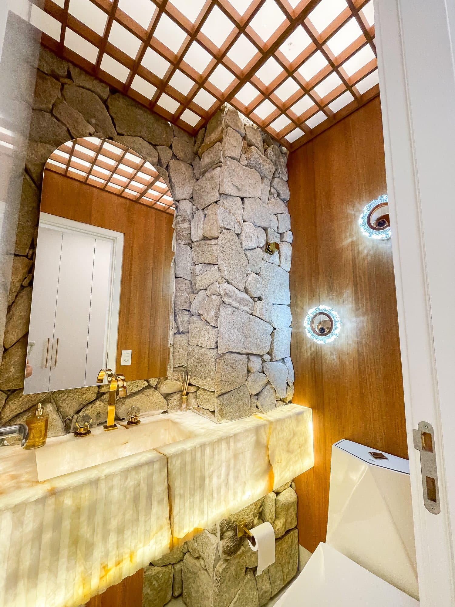 Lavabo com bancada em ônix iluminado e pedra natural