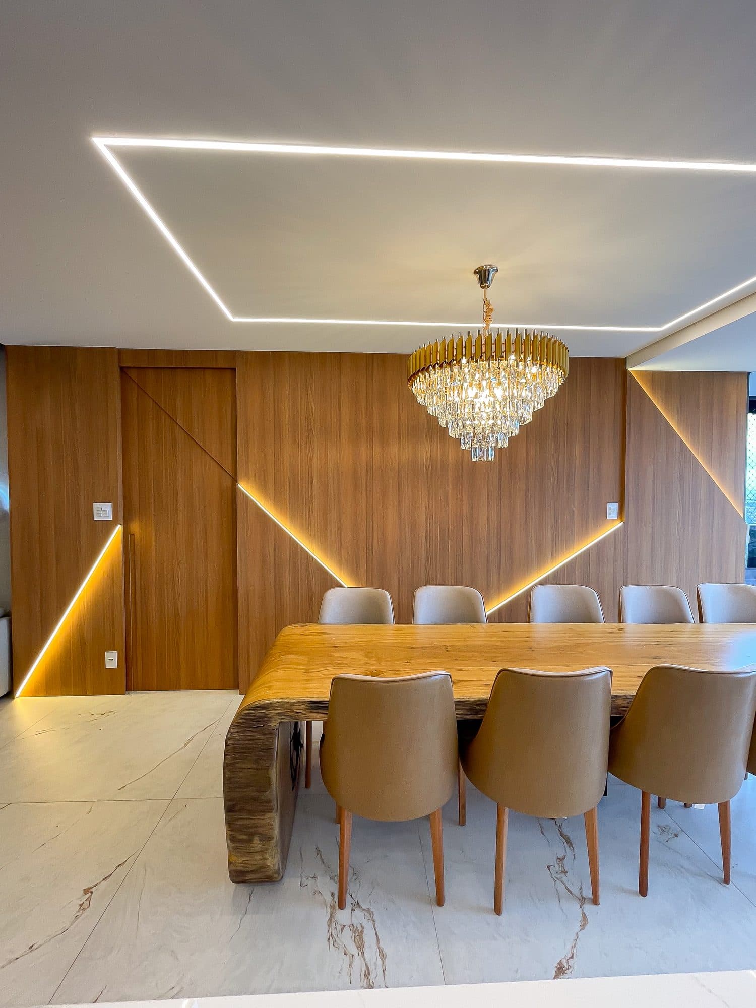 Sala de jantar com marcenaria em madeira, mármore e detalhes dourados